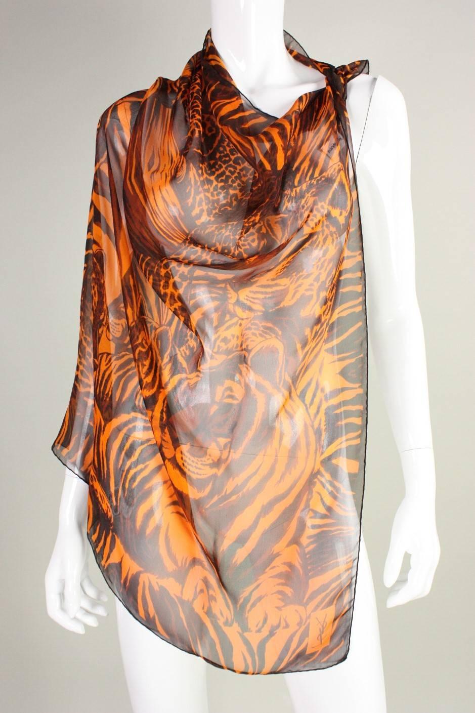 Classic silk chiffon scarf from Yves Saint Laurent features a leopard print in hues of orange and brown.  Hand-stitched rolled edges.  Scarf measures 33