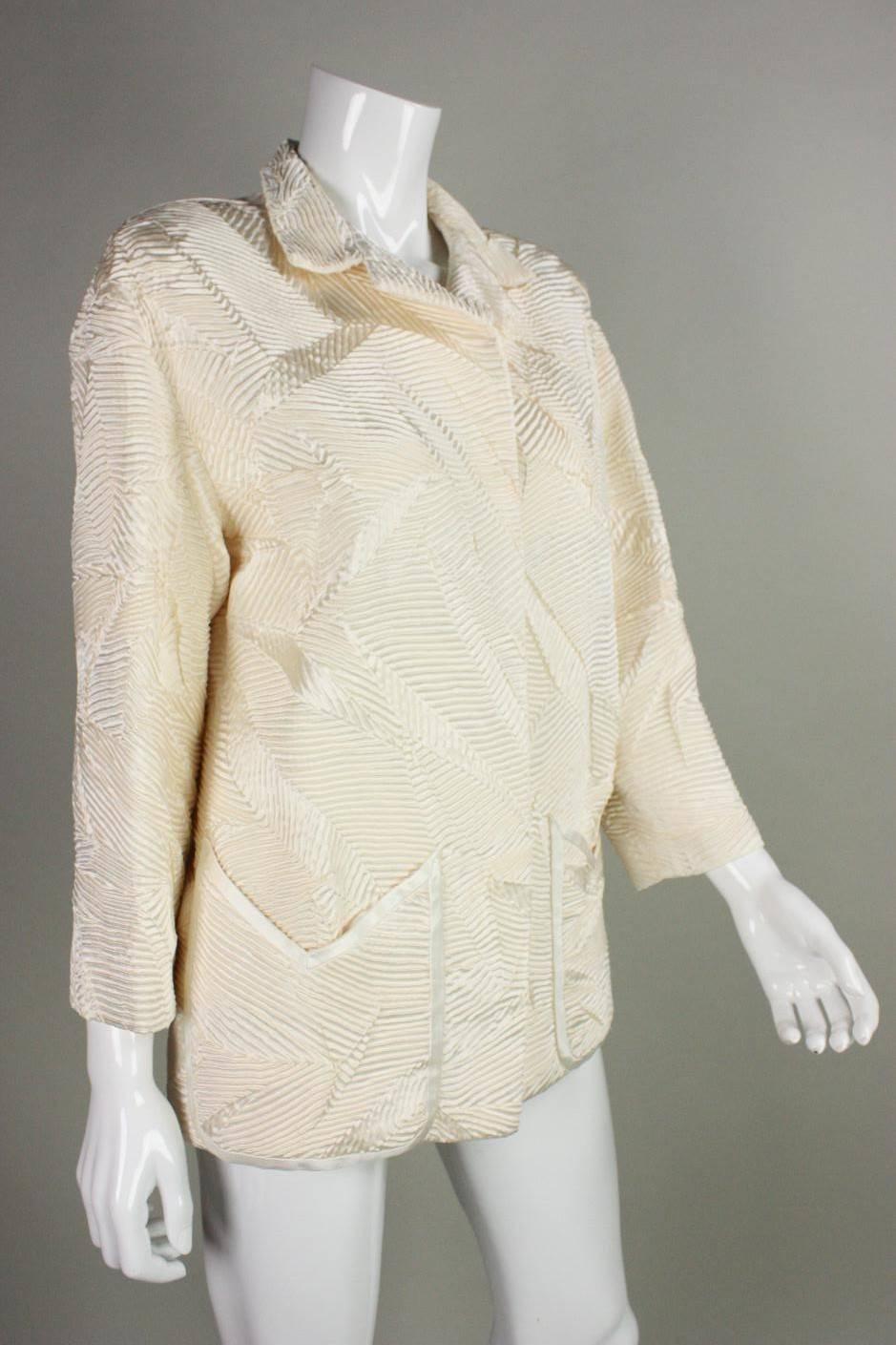 Vintage jacket from James Galanos dates to the 1980's and retailed at I. Magnin.  It is made of cream-colored textured silk.  Turn down collar.  Patch pockets.  No closures.  Fully lined.

Measurements-
Bust: 40