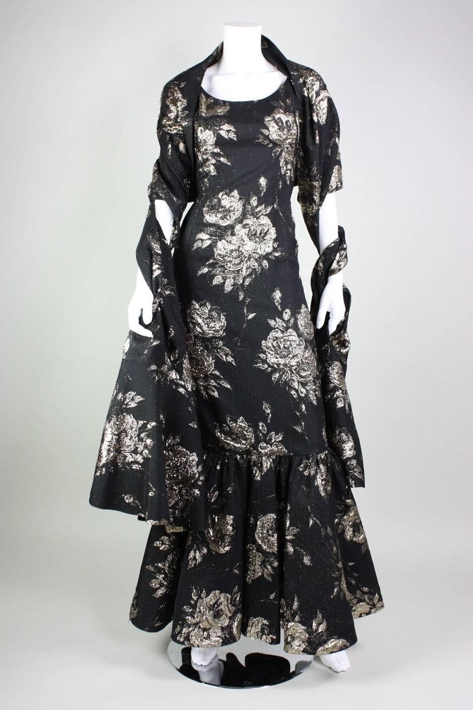 Stunning gown and wrap from Beverly Hills designer Maxwell Shieff dates to the 1950's and is made of black and gold jacquard with a large-scale floral motif.  Gown is fitted throughout outside of a fishtail hem.  Dress is lined and has a center back