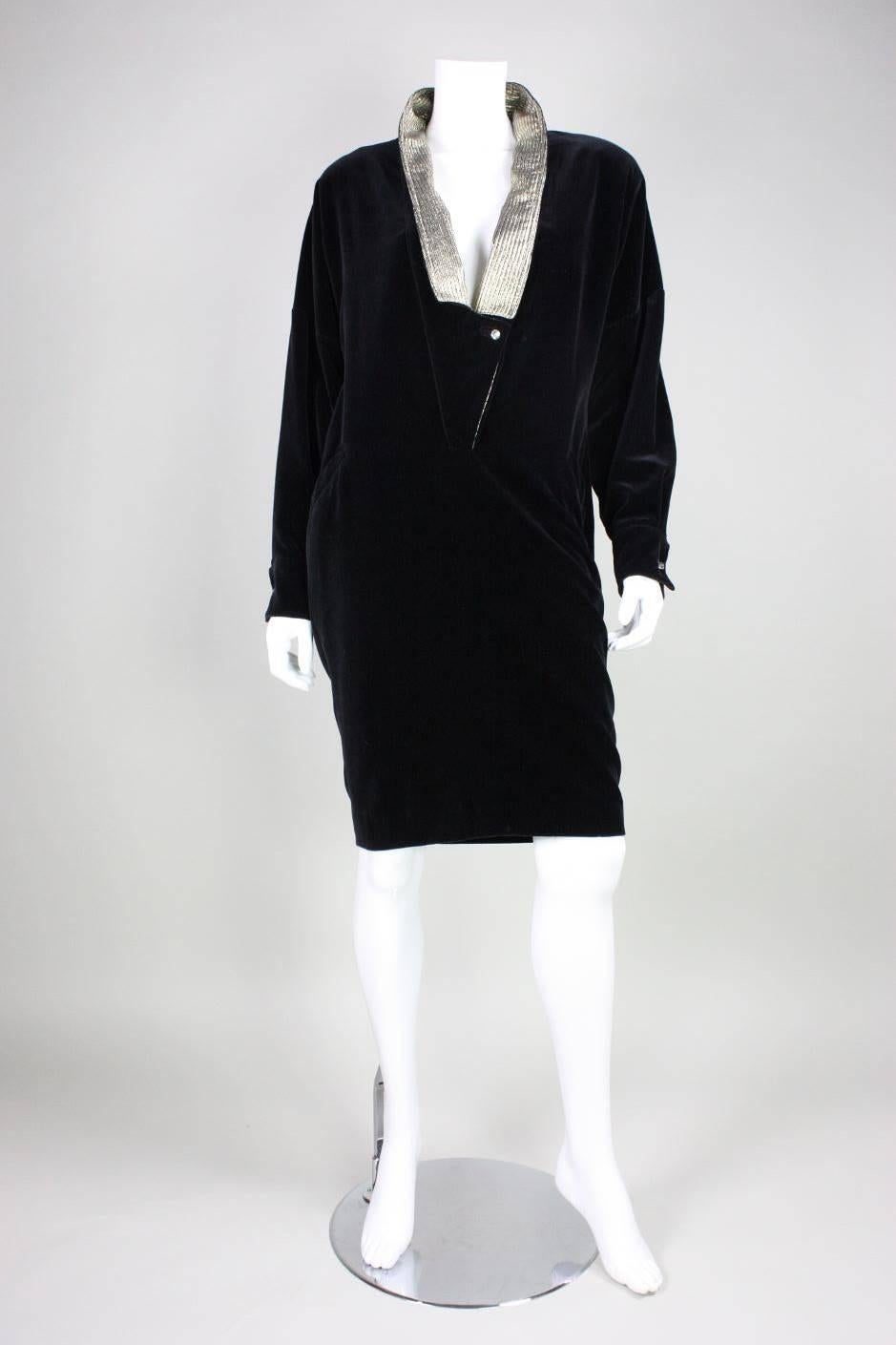 Vintage dress from Gianni Versace dates to the 1980's and is made of black velvet.  Metallic gold trim along neckline.  Long sleeves with French cuffs.  Deep center front v-neck.  Hip pockets.  Unlined.

No size label. Please refer to