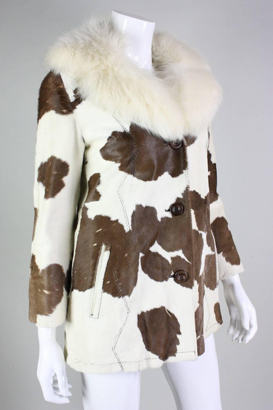 Vintage jacket from Revillon Boutique retailed at Saks Fifth Avenue and dates to the 1970's.  It is made of white and brown spotted calfskin with a white fox fur collar.  Large zigzag vertical top-stitching on front and back sides.  Hip pockets.