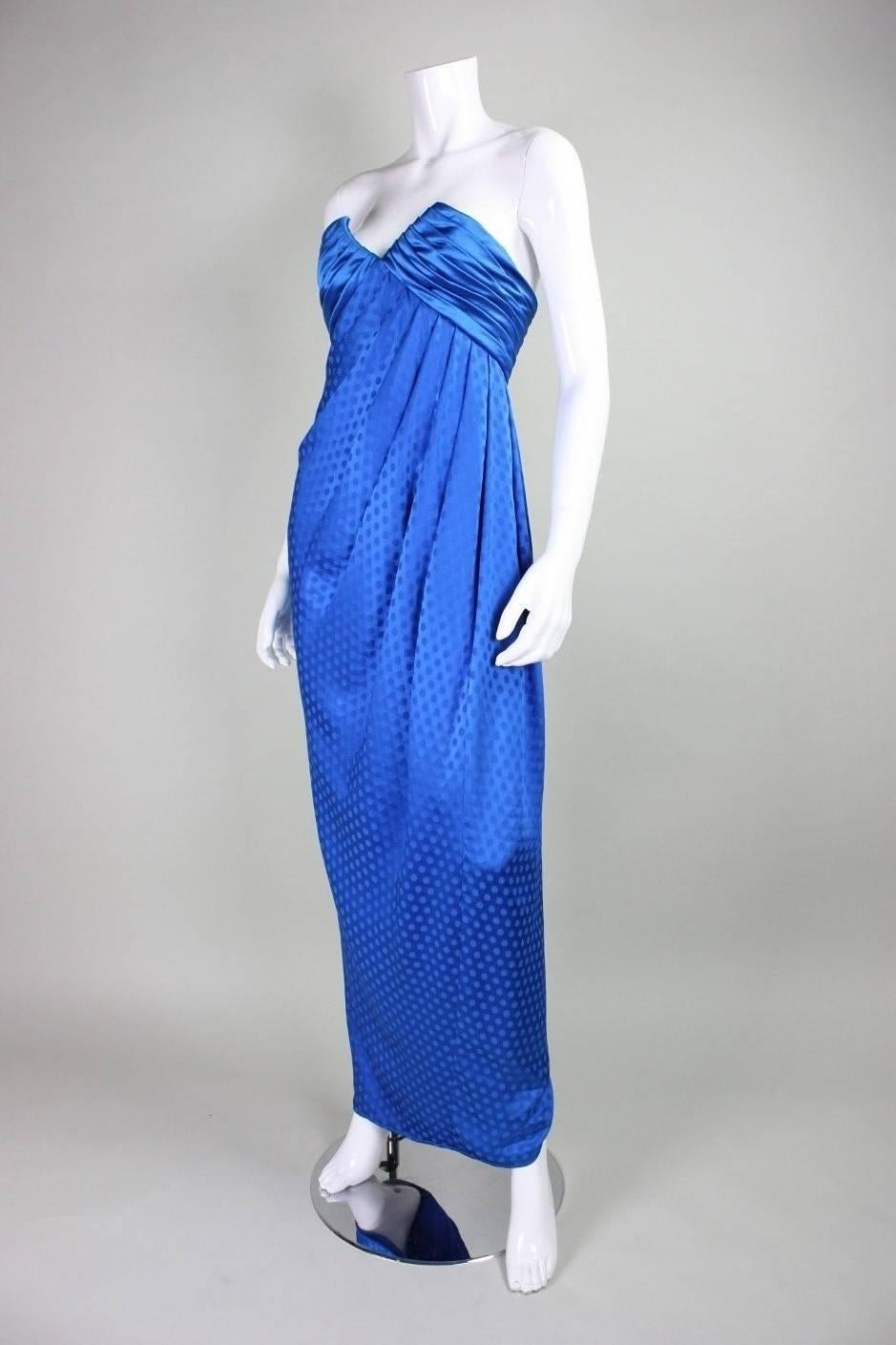 Emanuel Ungaro gown dates to the 1980's and is made of royal blue silk.  Strapless bodice has a v-neck and is pleated at bust.  Diagonal pleating radiates from the left under-bust downwards and creates an extremely flattering silhouette.  Lined. 