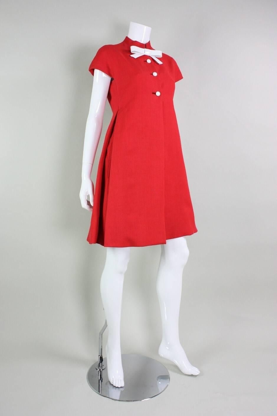 Vintage dress from Geoffrey Beene dates to the 1960's and is made of red linen with white vinyl detailing. Mock neck.  Short sleeves.  A-line shape.  Hip pockets.  Fully lined.

No size label, but we estimate it to be approximately a US size