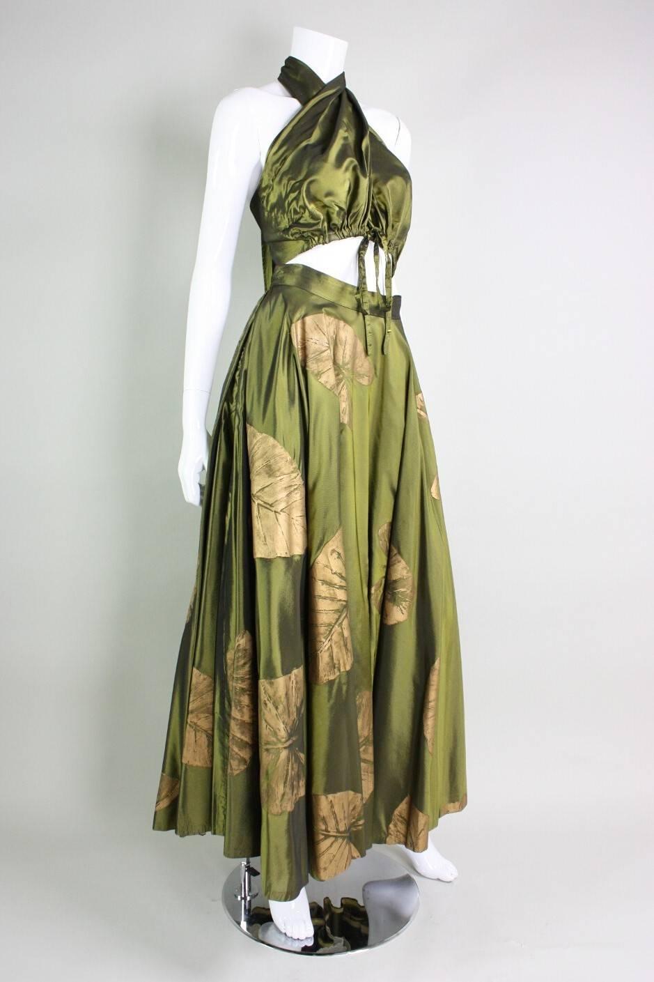 Vintage ensemble from Dorothy McNab dates to the 1950's and is made of olive green silk. Wrap-style bodice ties at waist with a drawstring and wraps around neck and ties at center back neck.  Full skirt features a leaf print that has been