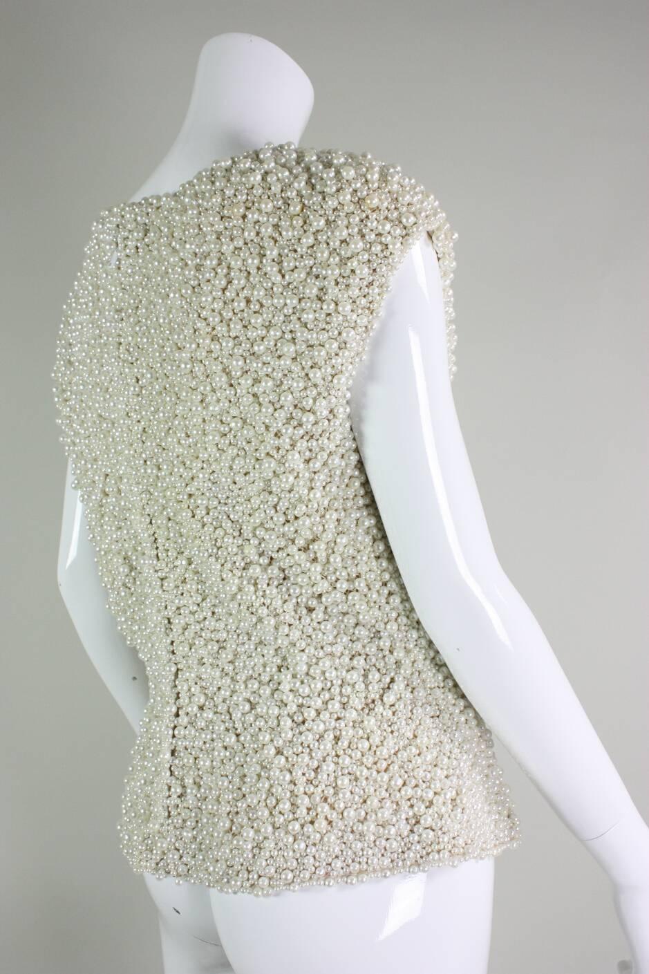 Vintage beaded shell from Oscar De La Renta likely dates to the 1990's and is completely covered with cream colored faux pearls of varying sizes which are attached to a net base.  Silk lining.  Center back zipper.

Vintage size 10, contemporary