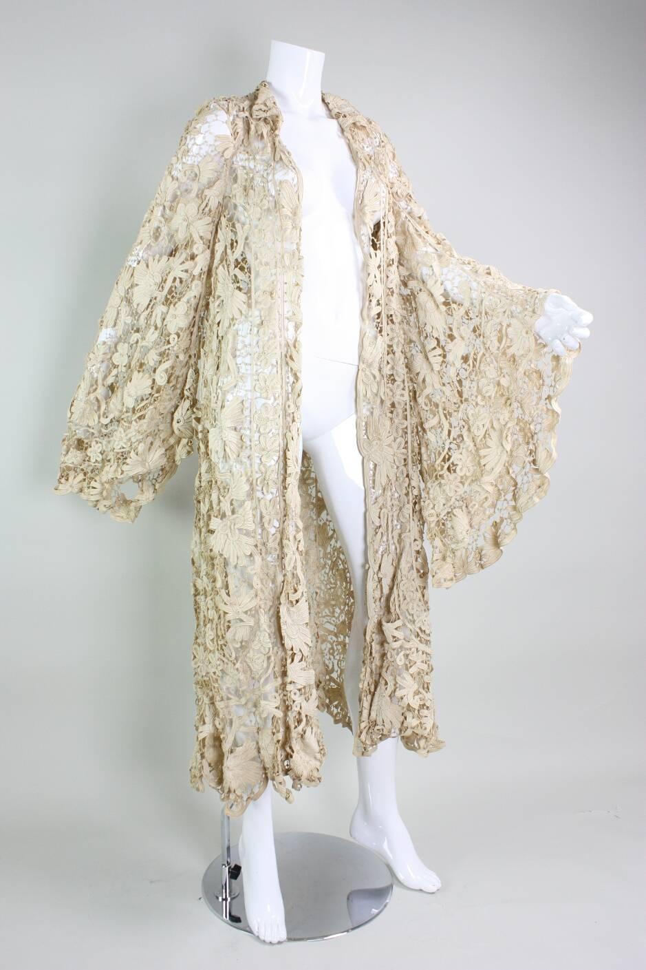 Antique coat dates to the Edwardian era and is made of ivory tape lace that is sewn in a scrolling floral pattern.  Unusual wide bell sleeves make this coat an extremely rare piece.  Turn down collar.  No closures.  Unlined.

Condition: Very good,