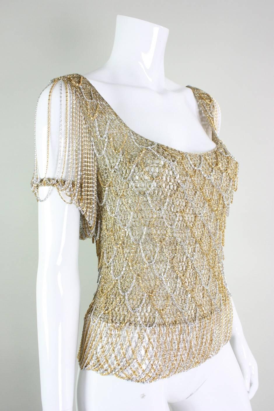 Loris Azzaro metallic gold sweater has silver and gold chain fringed accents and trim.  Deep cut front and back neck.  No closures. Unlined

Measurements-

Bust: 30-34