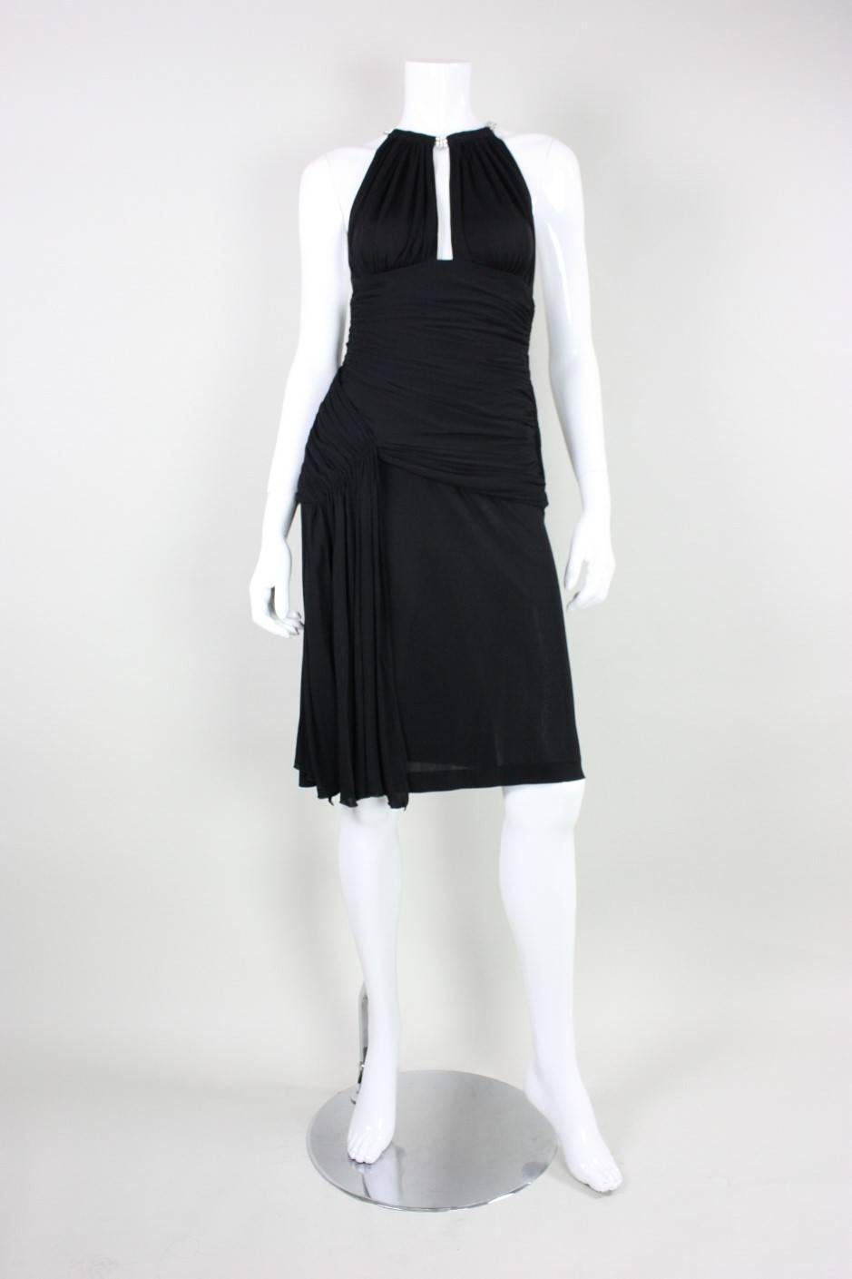 Vintage cocktail dress from Vicky Tiel dates to the 1980's. It is made of a black matte jersey with clear rhinestone straps.  Ruching throughout waist and hips.  Side zippered closure.  Lined through waist and hips, but not in skirt.
