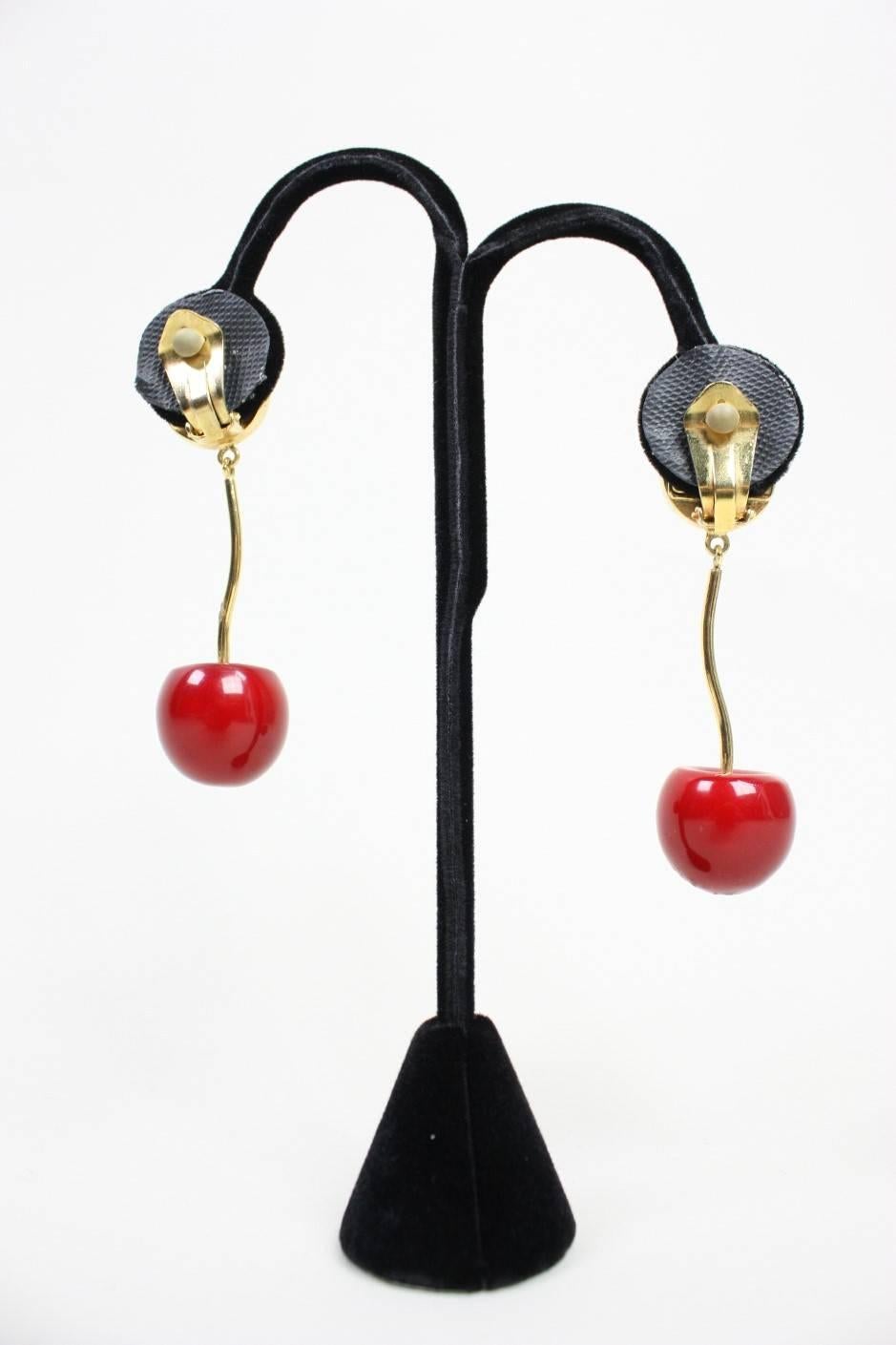 Vintage earrings from Valentino depict bright red cherries with gold-toned stems.  Faux pearl at earlobe.  Clip back.