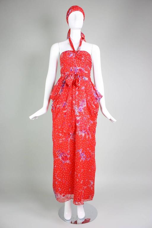 Vintage gown from Givenchy dates to the 1970's and is made of red silk chiffon with a floral print.  Bodice is fitted with a halter neckline that ties at the center back neck.  Ruched panels around the bust extend around the back bodice.  Cowl