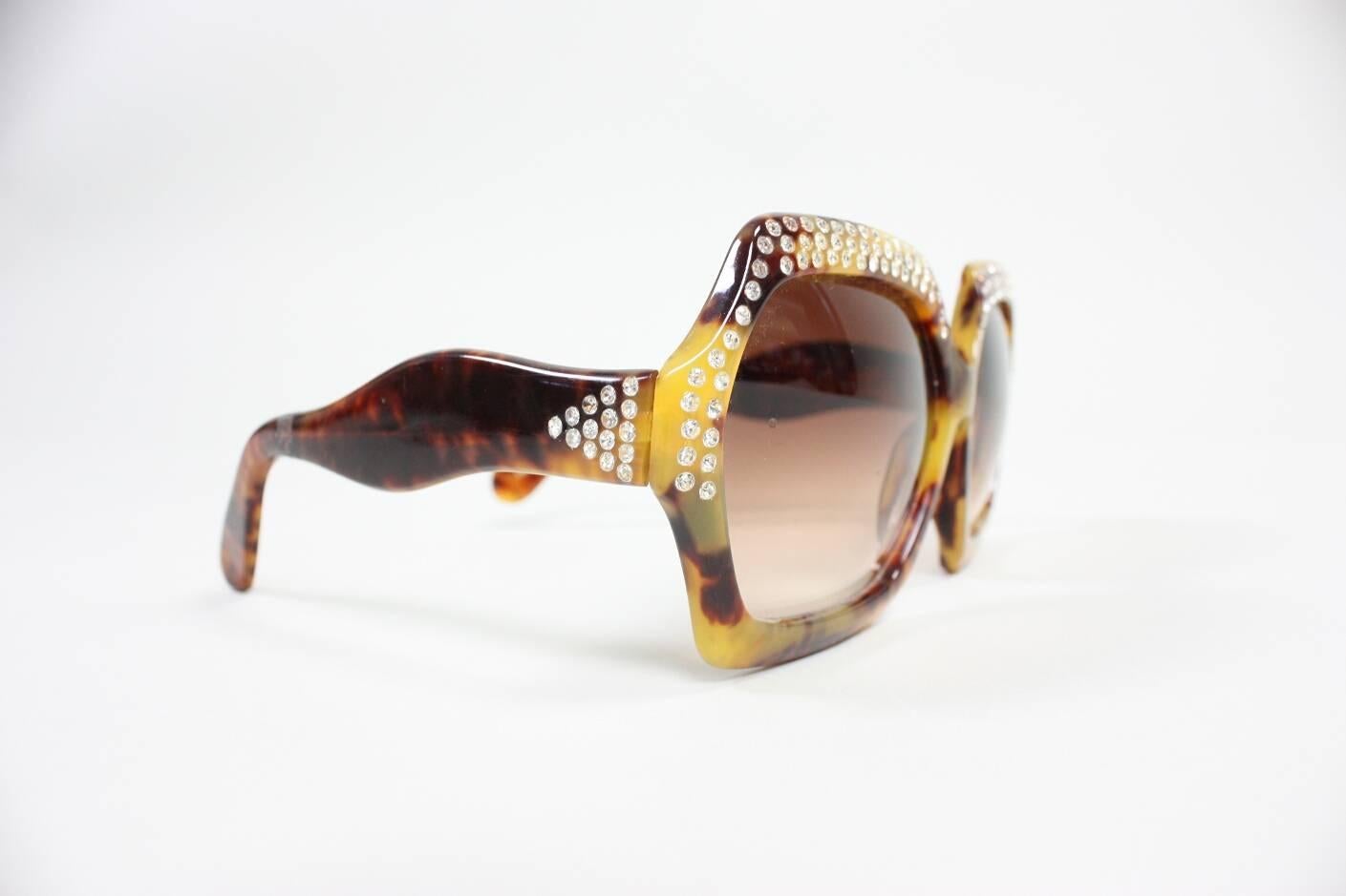 Vintage sunglasses from Pamela Designs are made of faux tortoise shell with rhinestones.

Condition: Excellent.

Measurements-

Frame Width: 6 1/2"
Frame Height: 2 3/4"
Arm Length: 5 1/4"