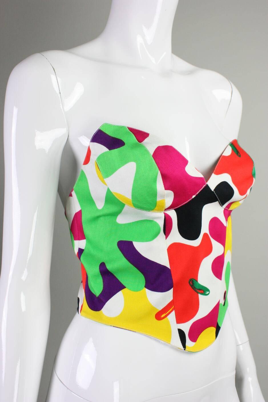 Vintage bustier from Thierry Mugler likely dates to the 1990's.  It is made of white cotton sateen with a colorful camouflage print.  Center back hook and eye closures.  Lined with self fabric. 

Labeled a French size 38.

Measurements

Bust: