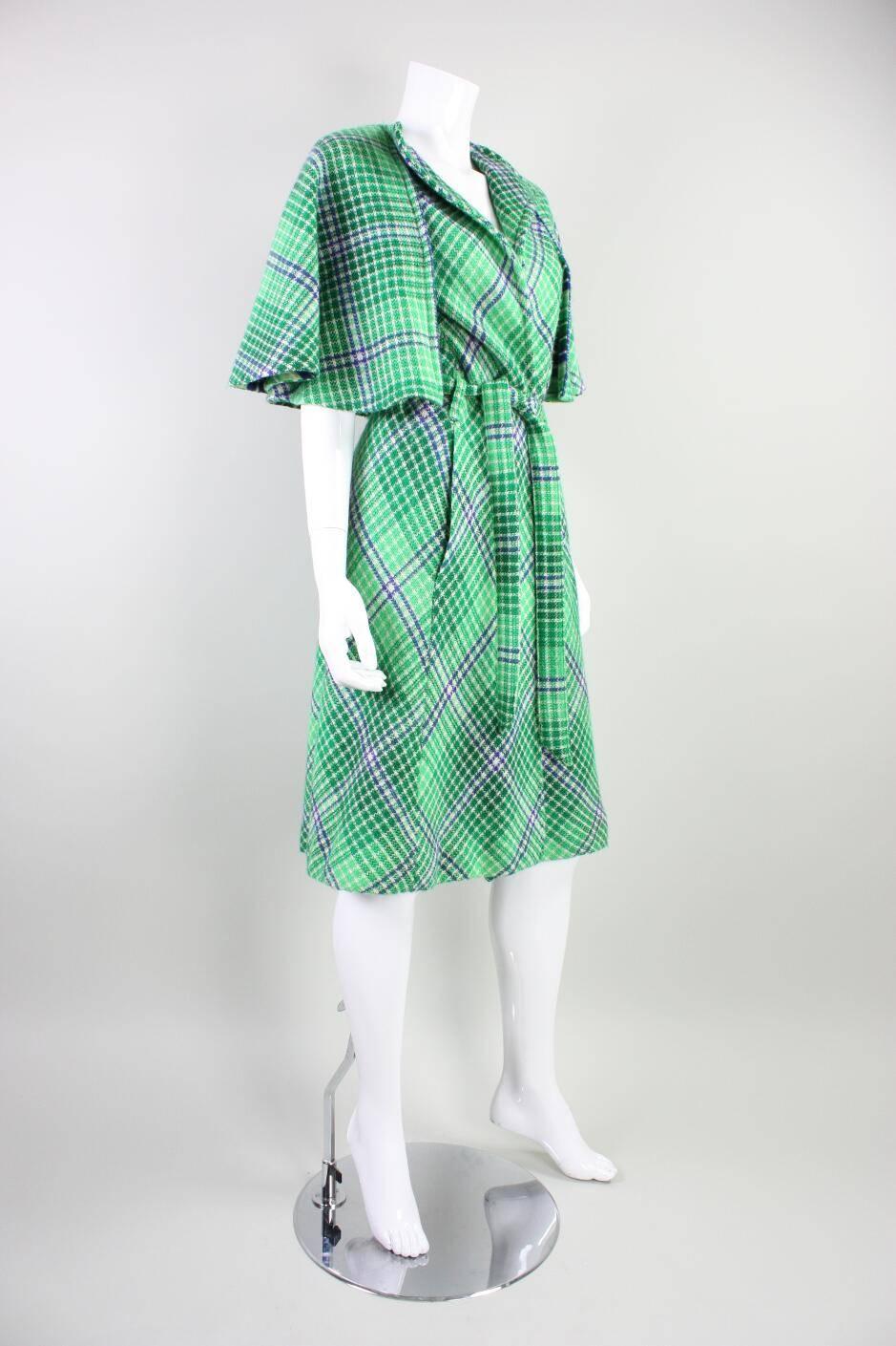 Vintage sleeveless coat from Missoni dates to the 1970's and is made of a green double-faced wool.  The exterior is a textured houndstooth pattern in green, white, and navy blue.  Lining has same color palette, but in a striped pattern instead. 