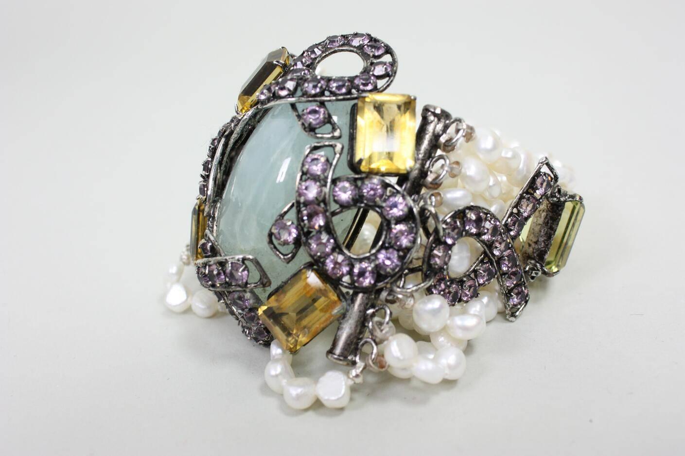 Beautiful statement bracelet from Iradj Moini is made of aquamarine, pearls, lemon quartz. To fasten the bracelet, a cylinder slides into a channel on the side of the center stone.

Measurements-
Length: 8 1/2"
Width: 3-3 1/2"