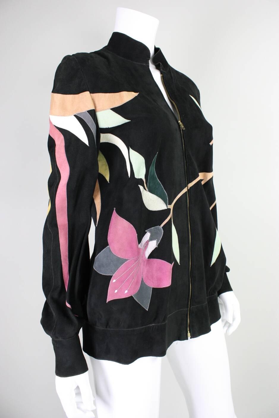 Vintage suede jacket from Roberto Cavalli dates to the 1970’s and is made of black suede that is appliqued with suede in pastel colors.  Dramatic bird on back features three-dimensional feathers.  Center front zipper.  Button cuffs.  Side waist
