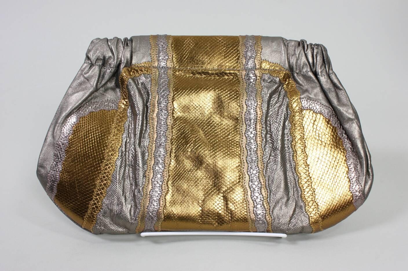 Vintage handbag from Carlos Falchi dates to the 1980's and is made of various types of skins with a metallic finish.  Narrow strap can either be worn over the shoulder or tucked away and the handbag used as a clutch.  Interior zipped pocket. Moire