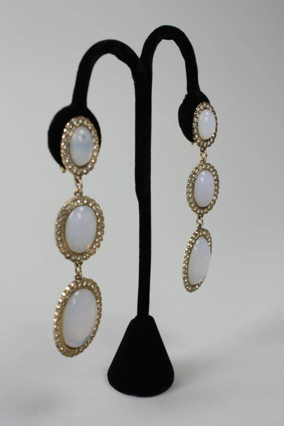 Vintage earrings from Butler & Wilson are comprised of clear rhinestones and milky white glass that resemble opals.  Gold-toned metal.  Clip backs.  Earrings are stamped B&W.

Measurements-

Overall Length: 3 1/2