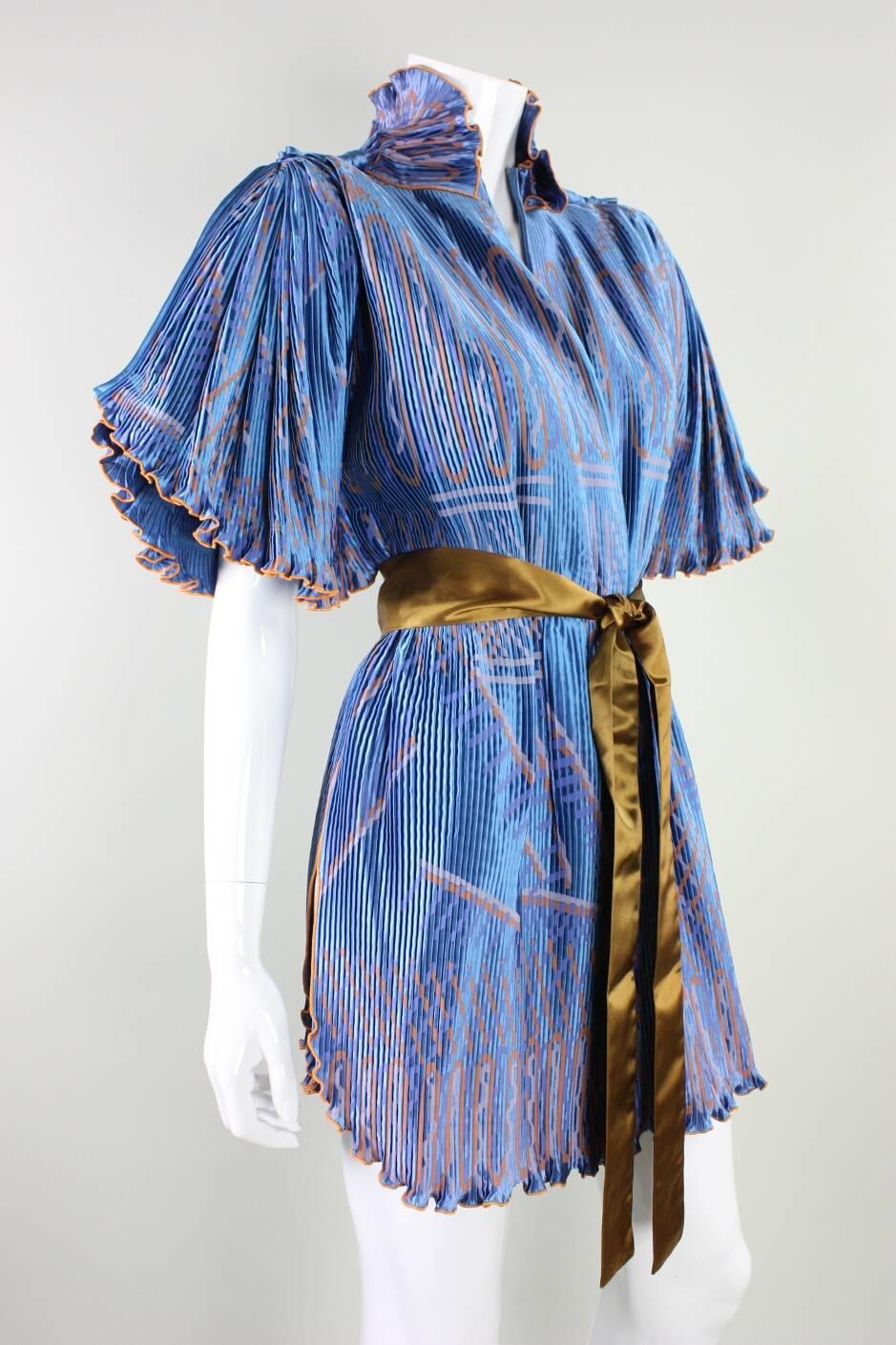 Vintage jacket from Zandra Rhodes dates to the 1970's through 1980's and is made of cornflower blue pleated rayon with an abstract pattern silkscreened throughout.  Detached sash also has the Zandra Rhodes label. Jacket is unlined and has no