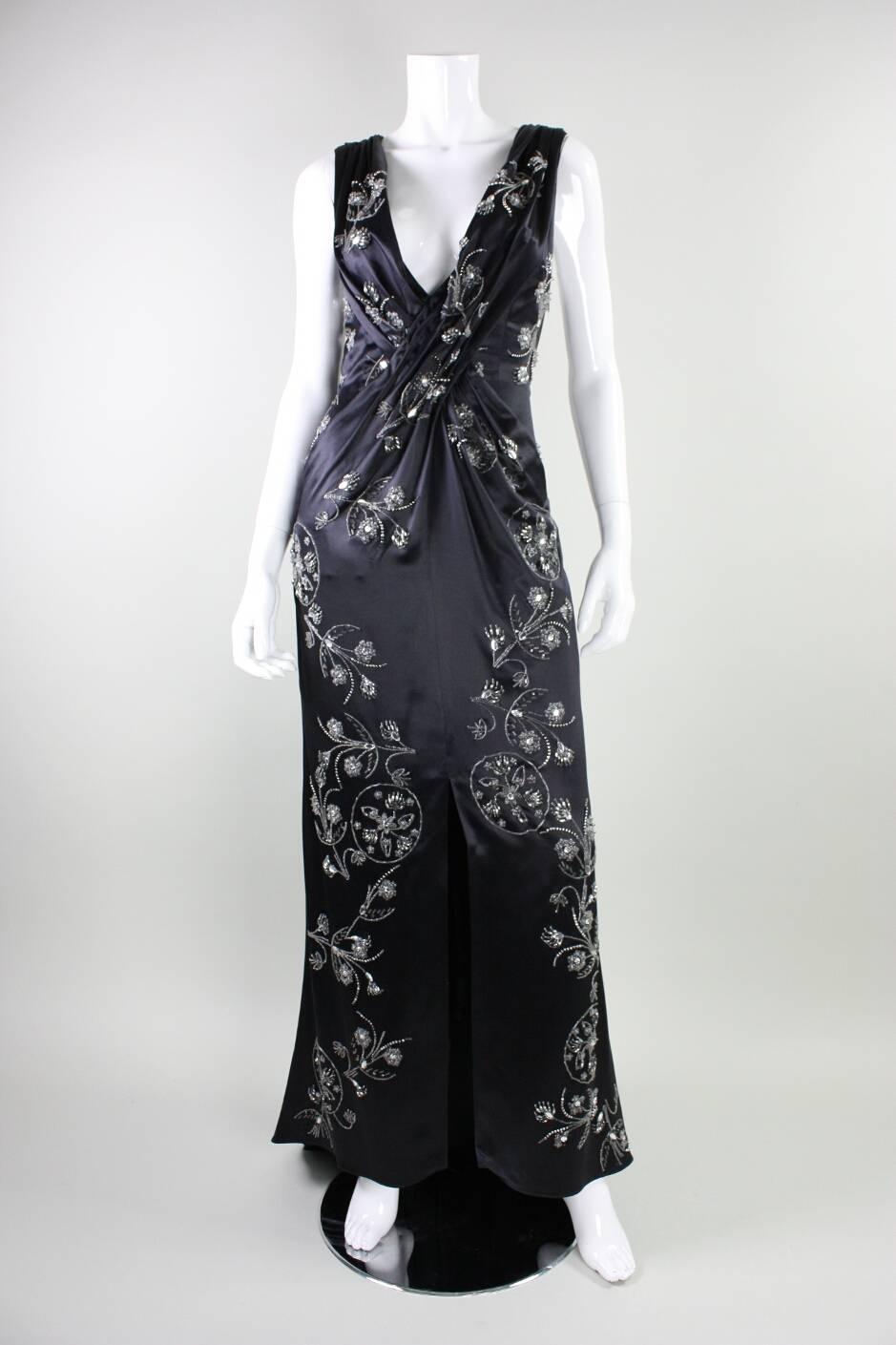 Gorgeous gown from Emanuel Ungaro dates to the 2000's and is made of black satin with beaded floral sprays sewn throughout.  Dramatic plunging neckline with gathers in the fabric below have a slimming effect on the waist.  Center front slit. 