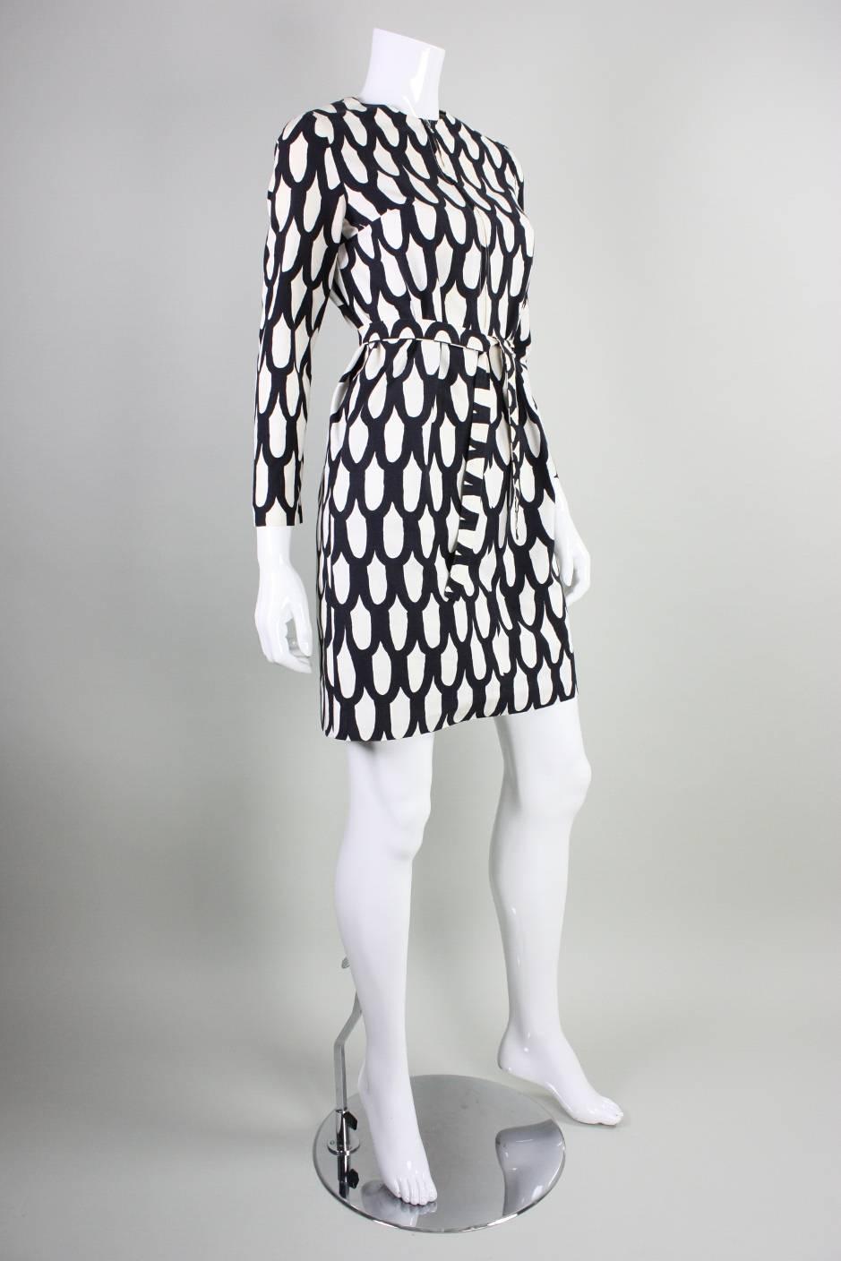 Vintage mini dress from Marimekko dates to 1965 and is made of white cotton with a black allover optical print. Long tapered sleeves.  Center front zippered closure extends to stomach.  Unlined.  Optional detached sash.

Labeled a vintage size 8. 