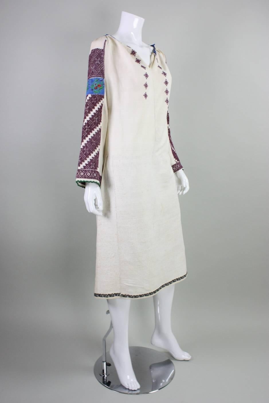 Vintage Eastern European folk dress likely dates to the 1930's or prior. It is made from cream linen with fine hand-embroidery on the sleeves, at hem, and front bust.  Underarm gussets. Unlined.  No closures.

No size label. Please refer to