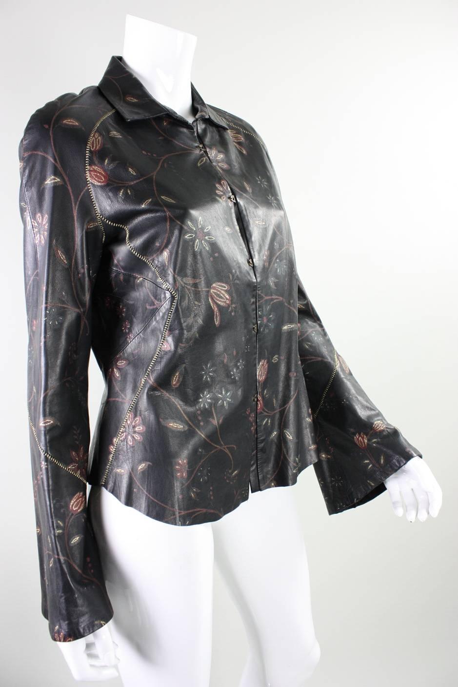 Roberto Cavalli buttery soft leather blouse or jacket has a rock & roll and western vibe.  It features slightly belled sleeves, gold-metallic stitching, and dark red and gold flowers.  Center front metal closures.  Partially lined.

Labeled size