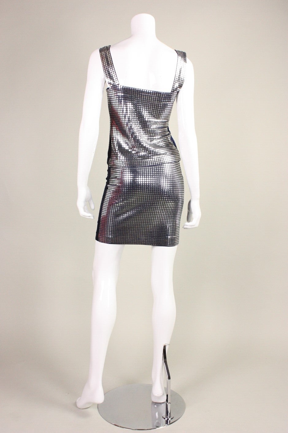 Vintage ensemble from Paco Rabanne dates to the late 1980's.  It is made of a navy cotton/elastic blend that is almost entirely covered with small flat metal squares.  Tank and skirt both have side zip closures.  Lined.

Please note that in some