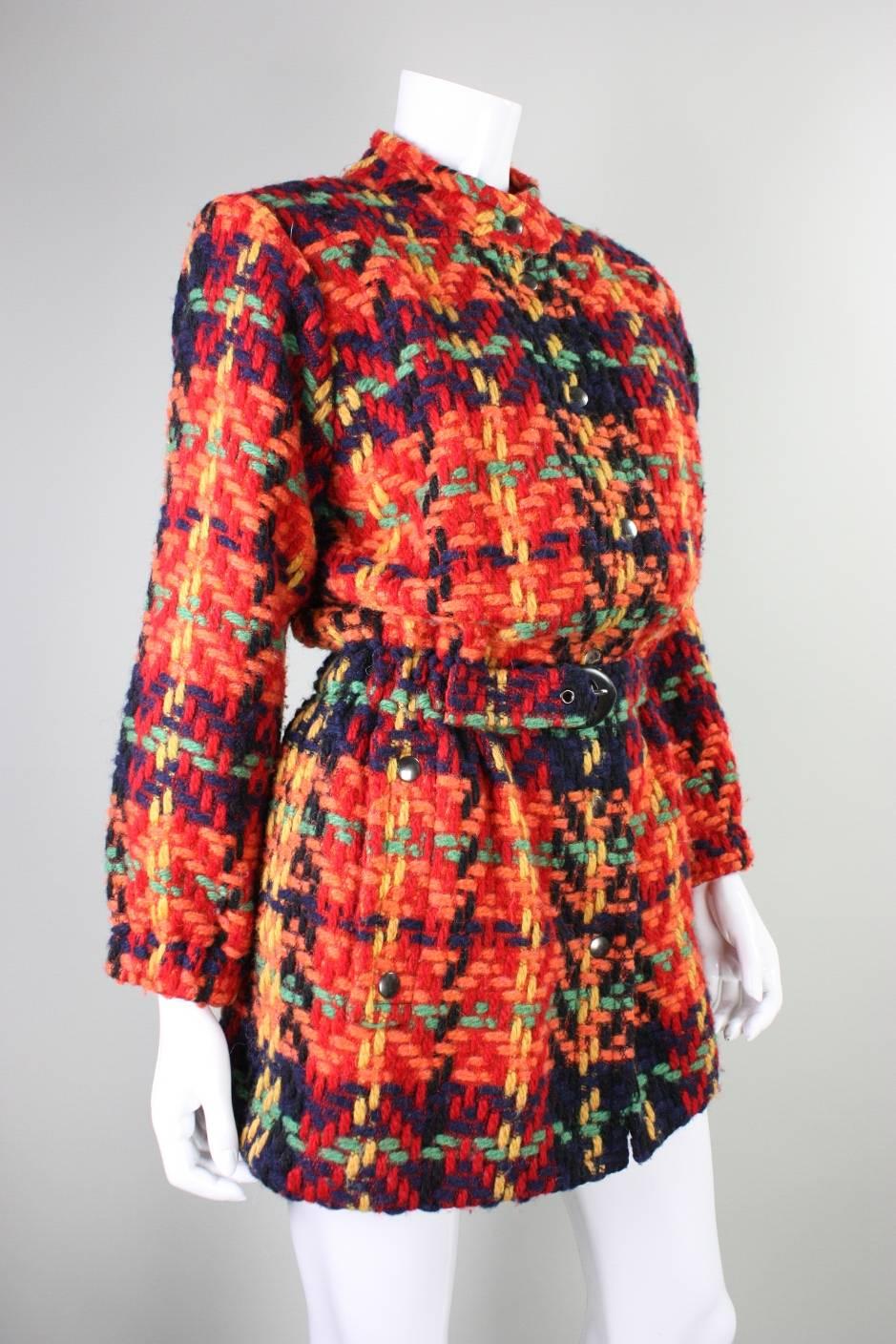 Fabulous jacket/coat from Yves Saint Laurent likely dates to the 1990's and is made of brightly-colored yarn that is woven in plaid tweed manner.  Center front snap closures.  Elasticized waist and cuffs.  Center front buckle closure at the waist. 