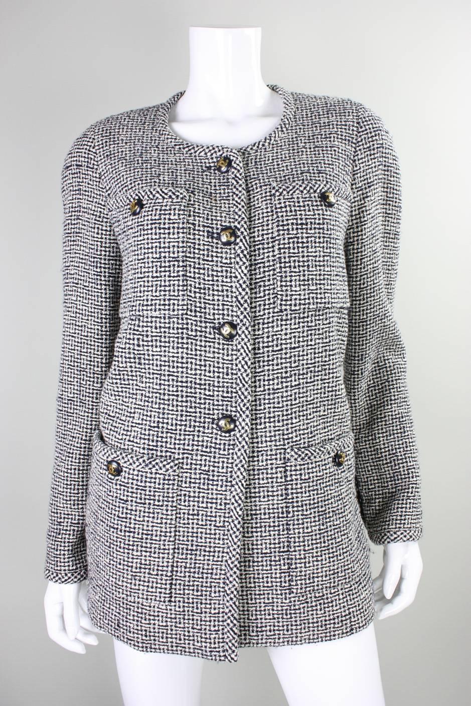 Vintage jacket from Chanel is made of black & white wool boucle and dates to the 1980's.  It features four front patch pockets and a center front closure.  All buttons have gold-toned interlocking C's.  Double back vents.  Fully lined.
Labeled size