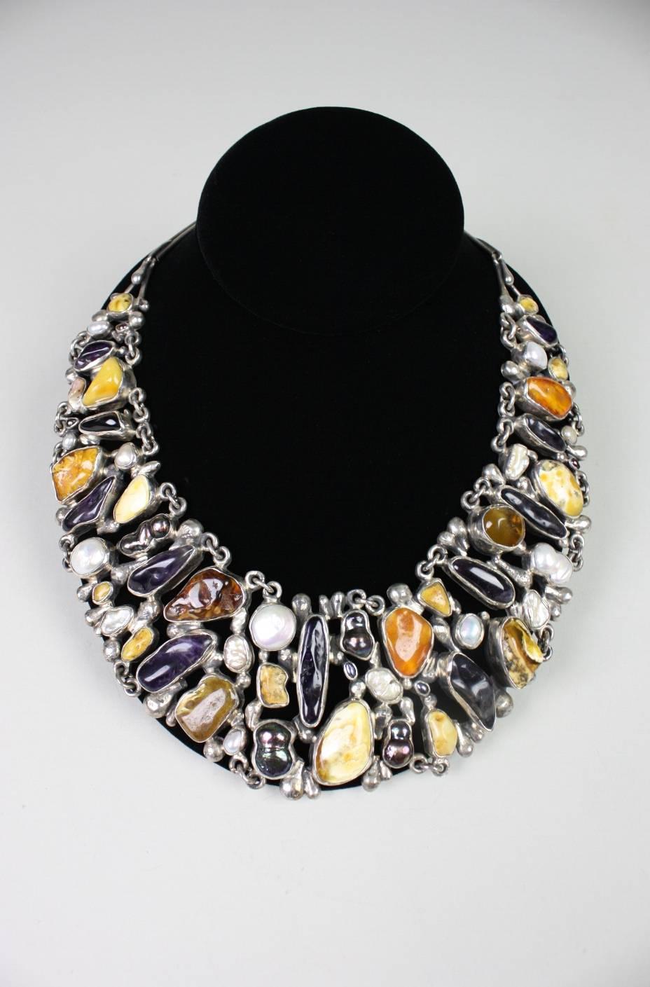 Stunning statement necklace from Jan Pomianowski  is comprised of nuggets of Baltic amber and amethyst along with pearls that are set in polished sterling silver. 

About Jan Pomianowski-
Jan Pomianowski was born in 1958. Graduated from the Faculty