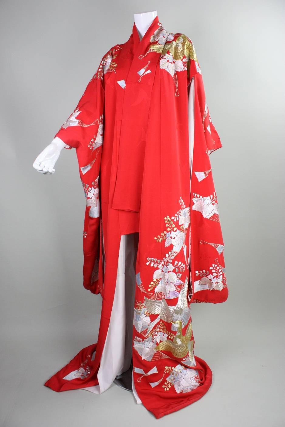 Vintage Japanese kimono features gorgeous metallic embroidery on a bright red ground. Lightly padded hem. No closures. Kimono dates to an unknown era during the 20th century.