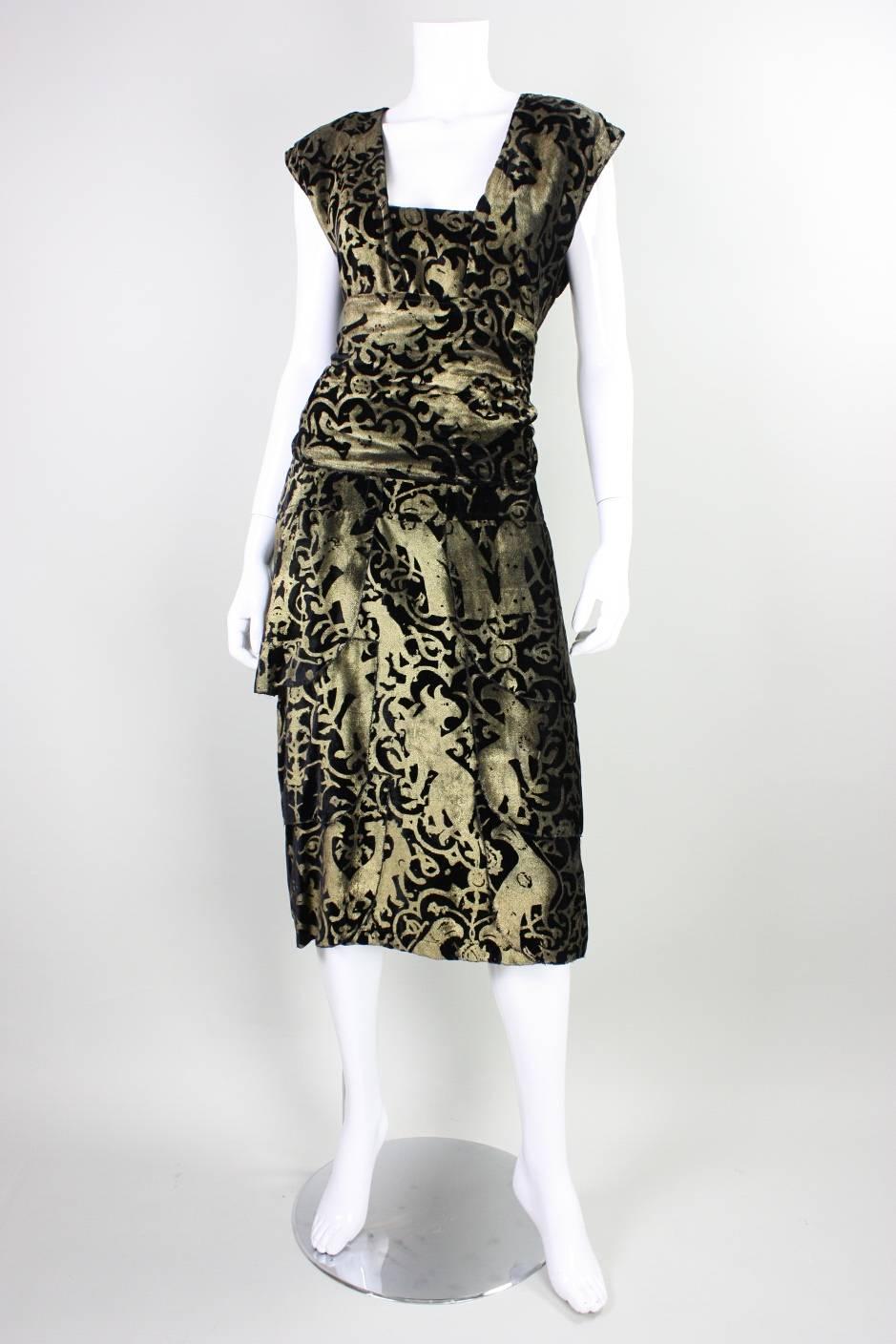 Vintage sheath dress from artist/clothing designer Fiorella Mancini and the Fiorella Gallery dates to the late 20th Century.  It is made of black velvet that features amorphous creatures that are stenciled allover in gold in the style of Gallenga. 
