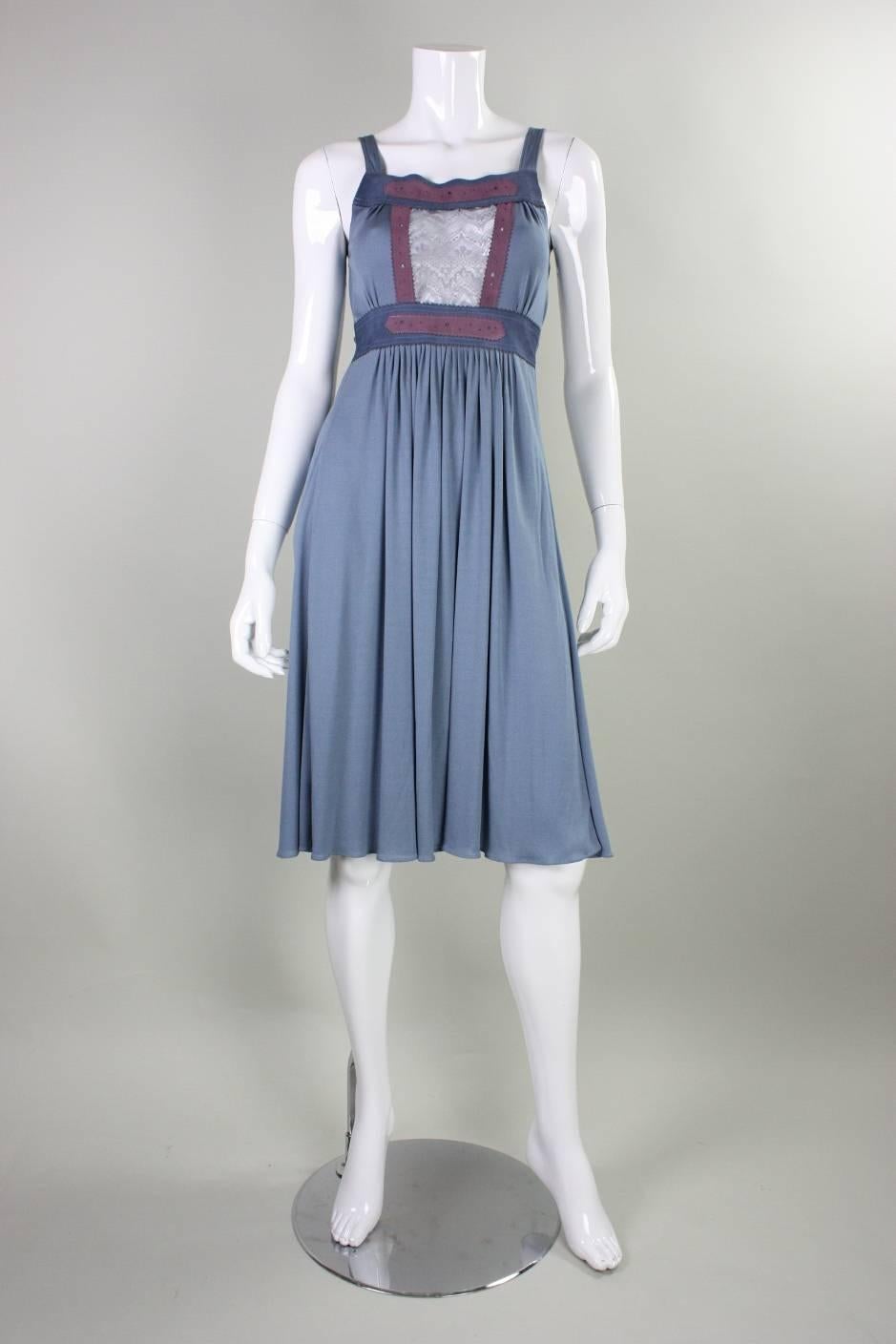 Vintage dress from Ann Buck dates to the 1970's and is made of slate blue matte jersey.  It features a sheer lace panel at center front bust and suede accents.  Attached tie ties at center back waist.  Unlined.  No closures.
We estimate this dress