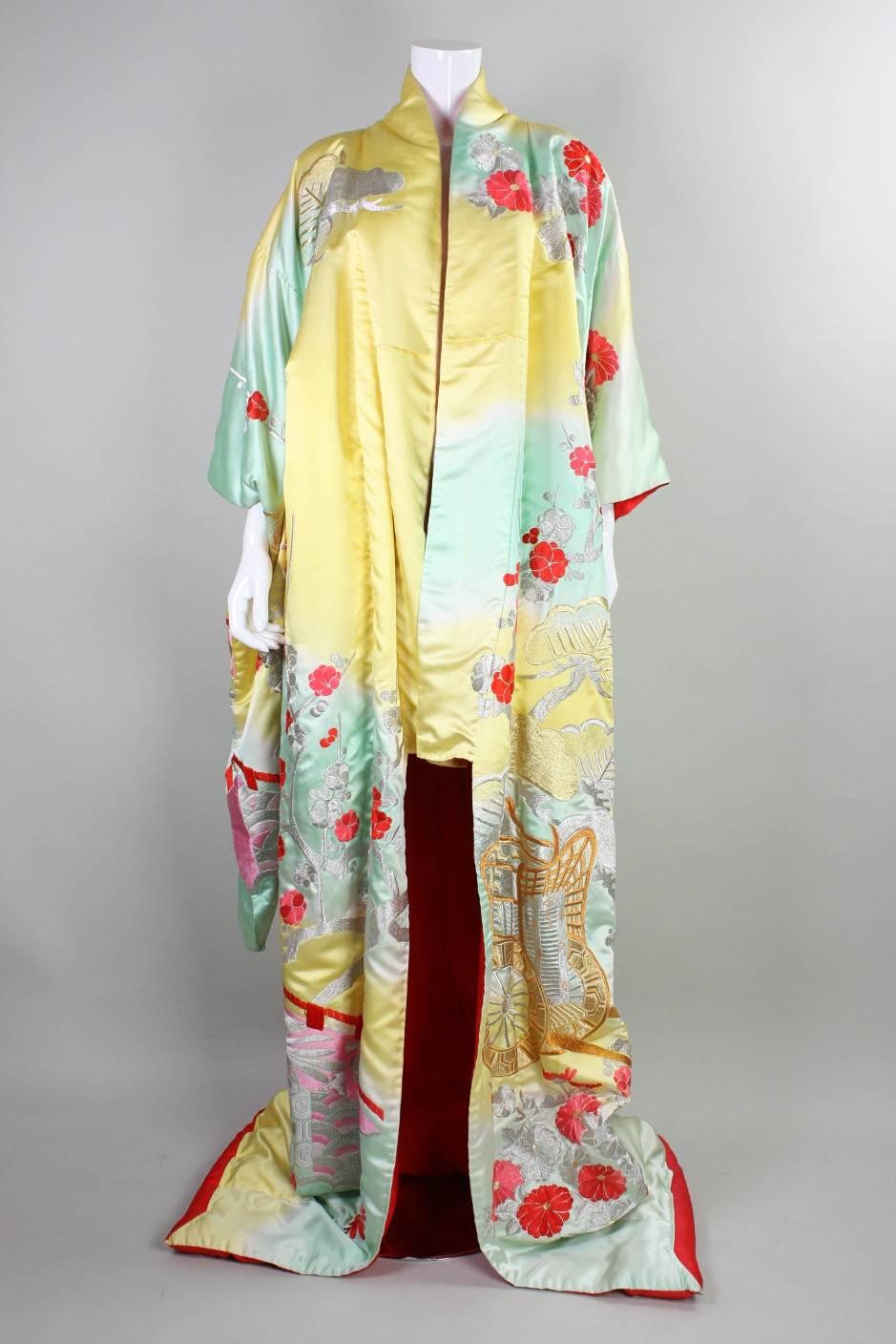 Vintage Japanese kimono features gorgeous polychromatic floral embroidery on an ombre silk ground that ranges from yellow to white to sea foam green. Padded hem. No closures. Kimono dates to an unknown era during the 20th century.