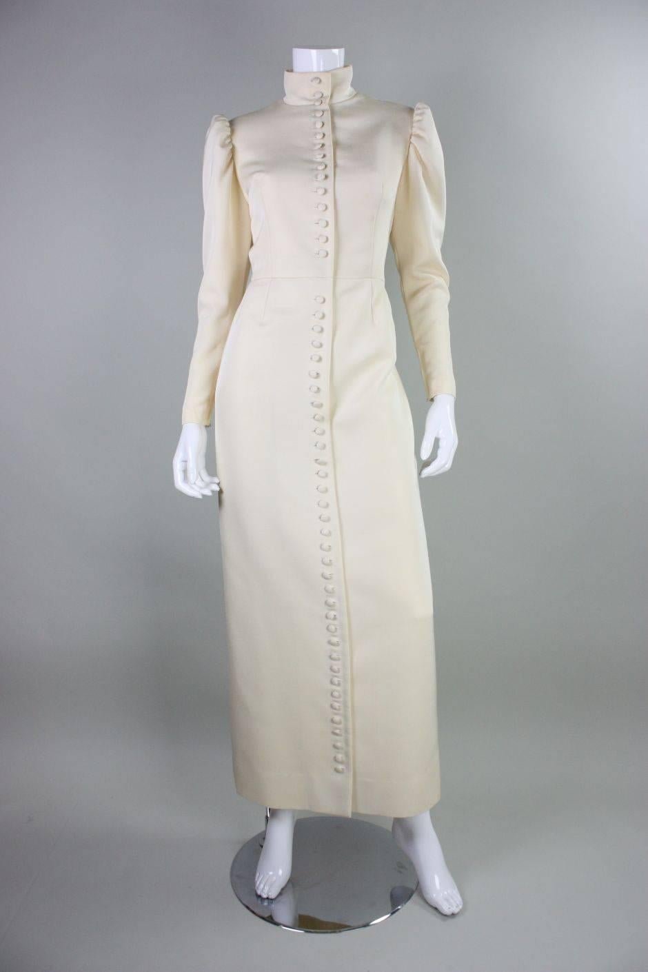Vintage evening gown from Lanvin dates to the 1970's and is made of cream-colored faille, possibly synthetic or a synthetic blend.  It features a mock neck, center front covered button closures, and a slight leg of mutton sleeve with zippered cuff. 