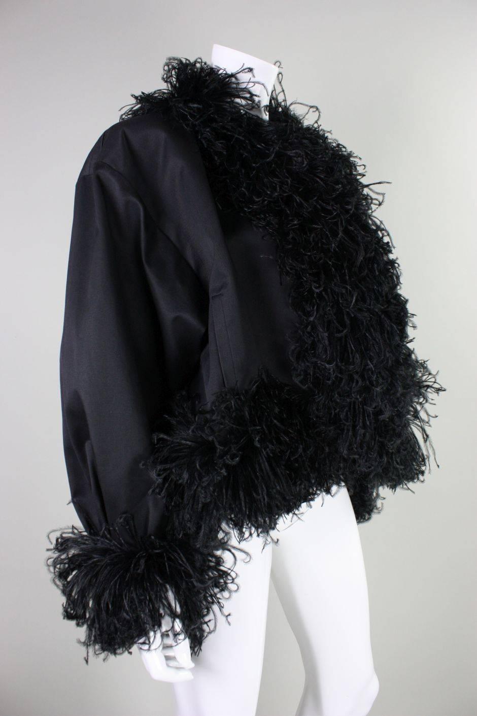 Vintage jacket from Yves Satin Laurent dates to the 1980's and is made of thick black cotton twill with flirty ostrich feather trim.  Dolman sleeves.  Fully lined.  No closures.  Side pockets at waist.  Padded shoulders.

Labeled a size 36, but this