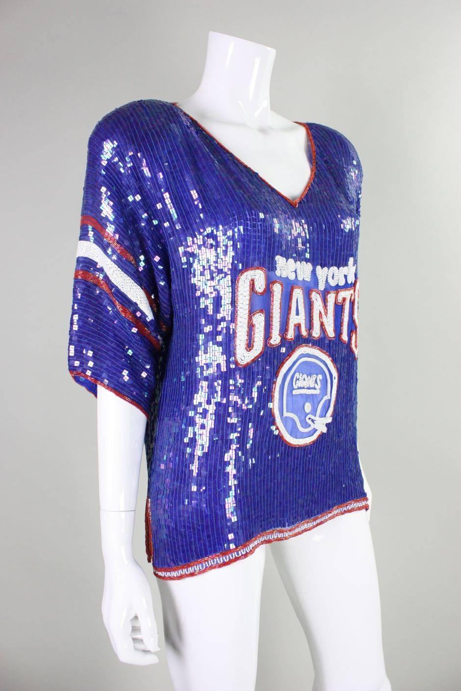 Vintage blouse from Concetta Rafanello for St. Martin dates to the 1980's and is made of blue chiffon that is fully covered with blue square sequins.  It features a New York Giants logo that is worked in bugle beads.  V-neck.  Short sleeves. 