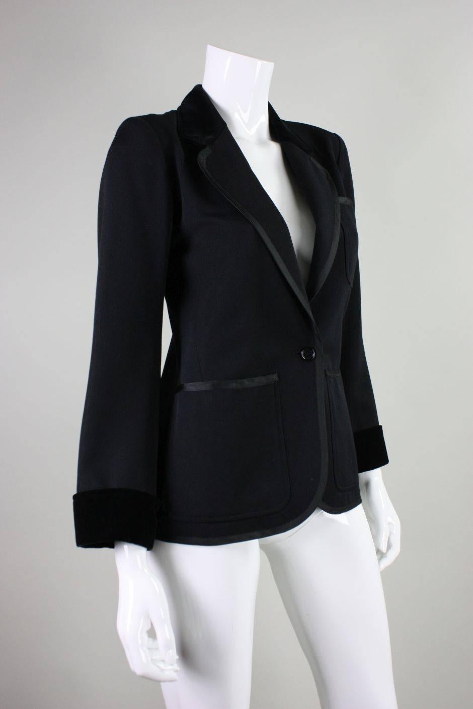 Vintage jacket from YSL dates to 1970's and is made of black wool with black velvet detailing at the collar and cuffs.  Notched lapel.  Three patch front pockets. Single center front button closure at waist.  Fully lined.  
Labeled size