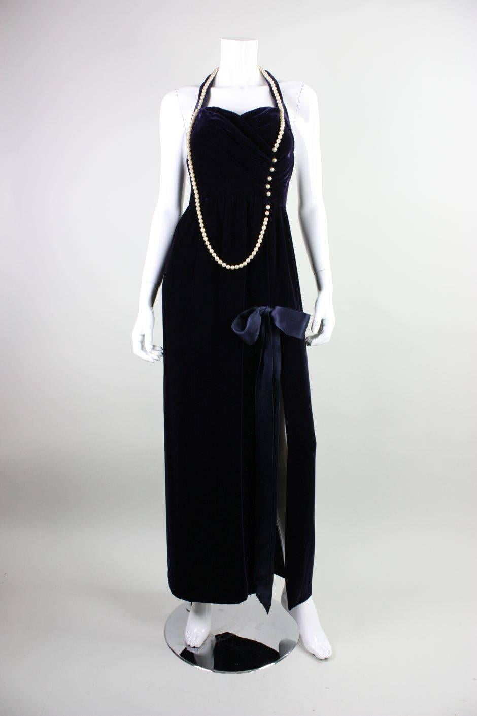 Vintage gown from Chanel was designed by Karl Lagerfeld in the 1990's.  It is made of midnight blue silk/rayon velvet with a strand of cream pearls that adorn the neckline and bodice.  Fitted bodice has halter sweetheart neckline and open back. 