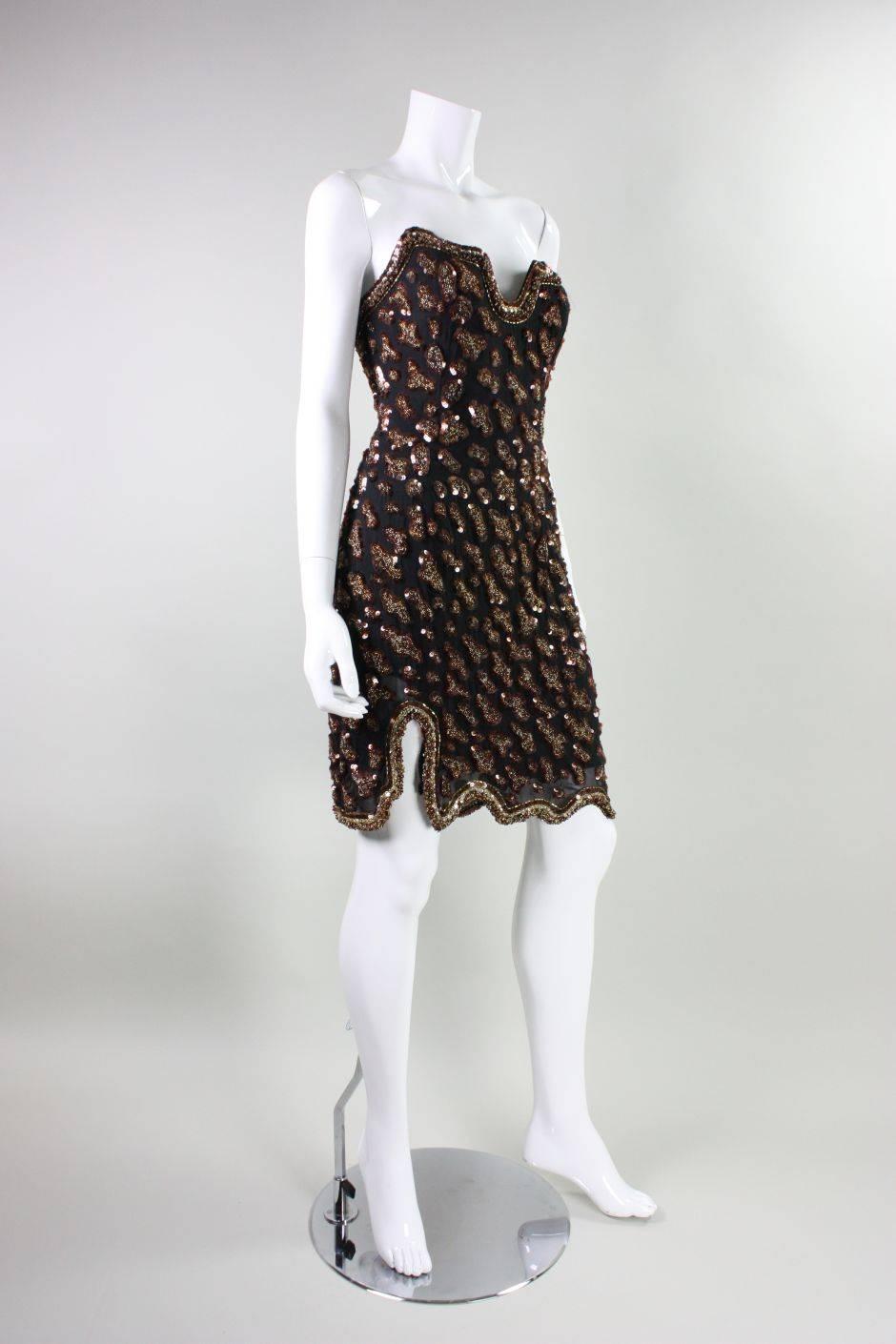 Vintage party dress from Fabrice dates to the 1990's and is made of black silk that features beading and sequins worked in a leopard pattern.  Front bodice and hem have asymmetrical borders and echo the pattern of the beading.  Bodice features
