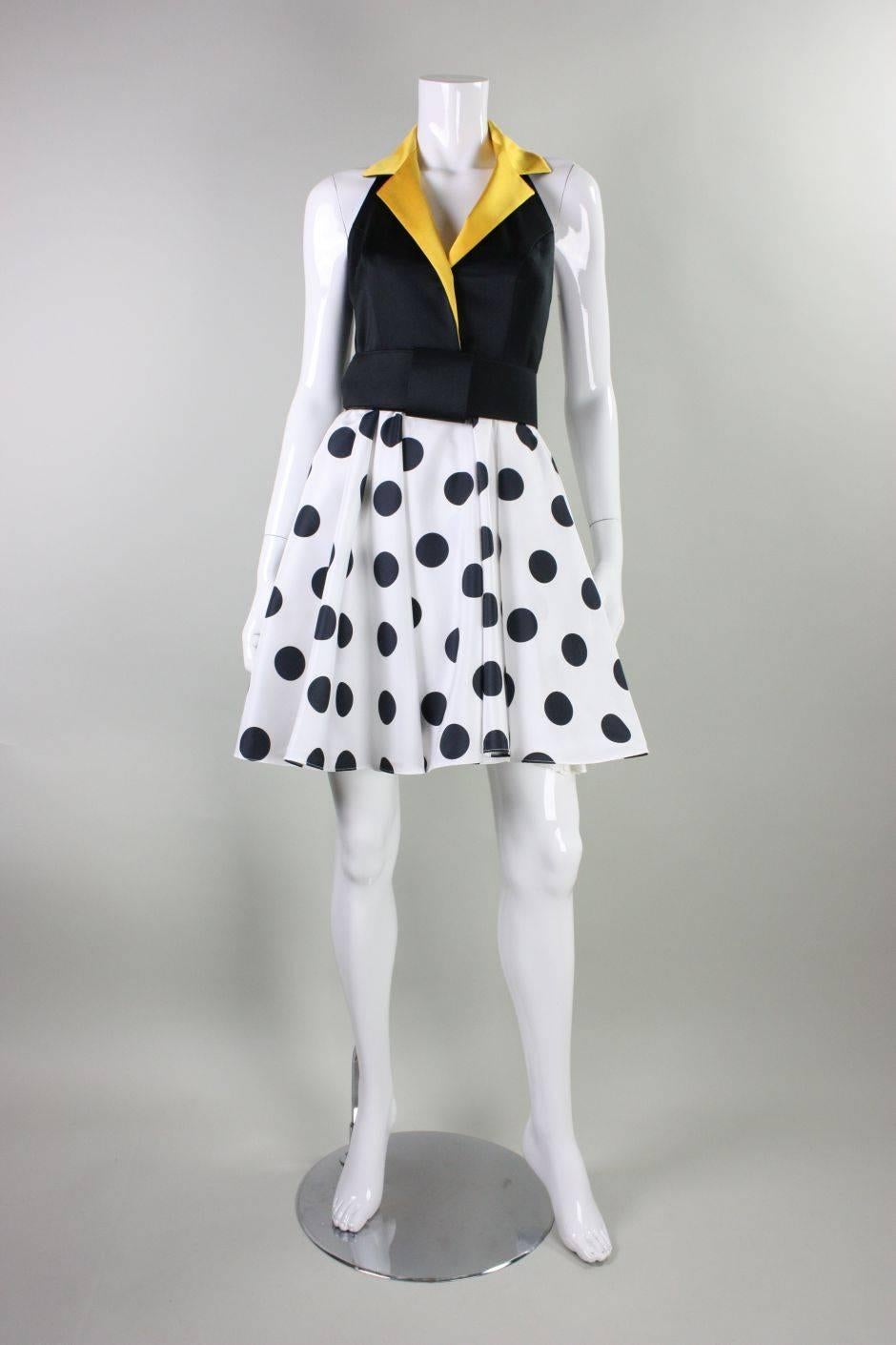 Vintage dress from Kathryn Conover New York by Night dates to the 1980's and features a black bodice with a yellow notched collar. Black and white polka-dotted skirt has a narrow band of synthetic horsehair to give it volume.  Detached wide belt has