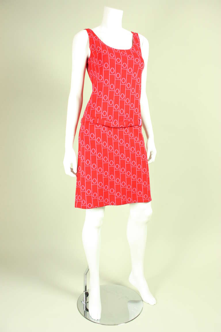 Vintage dress from Rudi Gernrich for Harmon Knitwear is made of red and lilac wool knit with a geometric Op-Art print.  Dress is sleeveless, has a scoop front and back neckline, and drop waist with detached belt.  Unlined.  No closures.

Labeled a