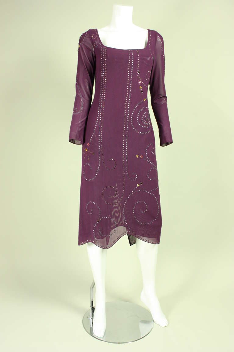 Vintage dress from Giorgio di Sant'Angelo dates to the 1970's and is made of plum-colored netting with rhinestones of different colors, sizes, and shapes that are prong-set throughout.  Scoop neck.  Long tapered sleeves.  Center back slit in skirt. 