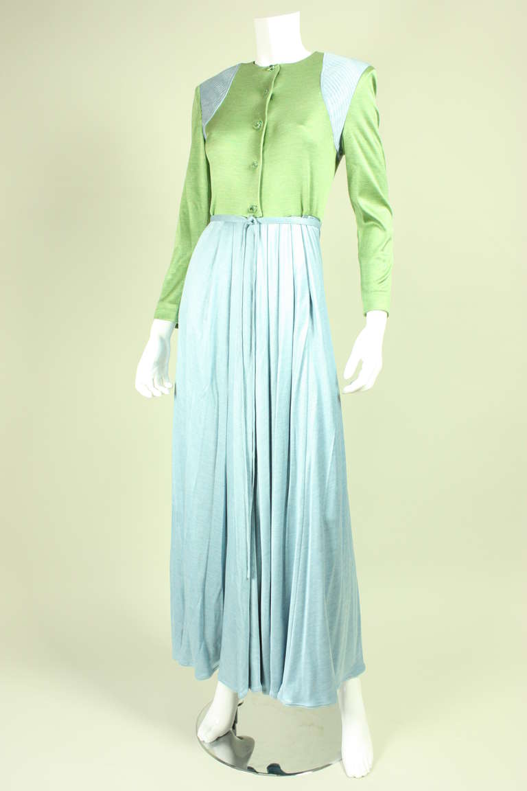 Vintage dress from Geoffrey Beene dates to the 1980's and is made of ice blue and sage green silk jersey.  Fitted bodice has round neck, long sleeves, and center front glass button closures.  Full skirt has side pockets.  Detached belt. 