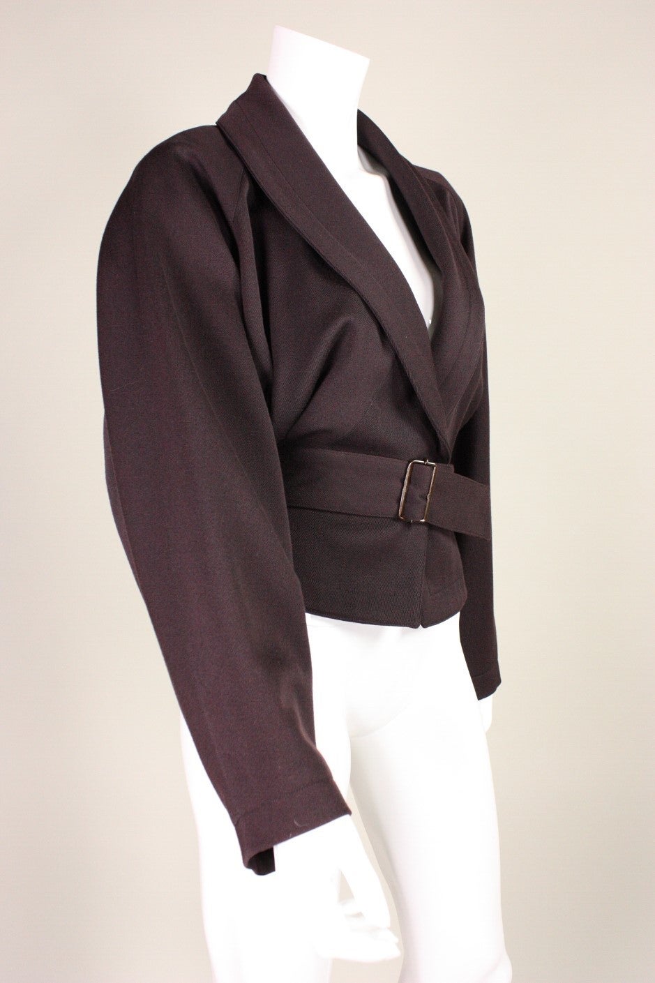 Vintage jacket was designed by Azzedine Alaia and retailed at Bergdorf Goodman.  It is made of chocolate brown wool and features a wrap around belt.  Single snap closure at center front waist.  Great pleated detailing at side waist.  Fully