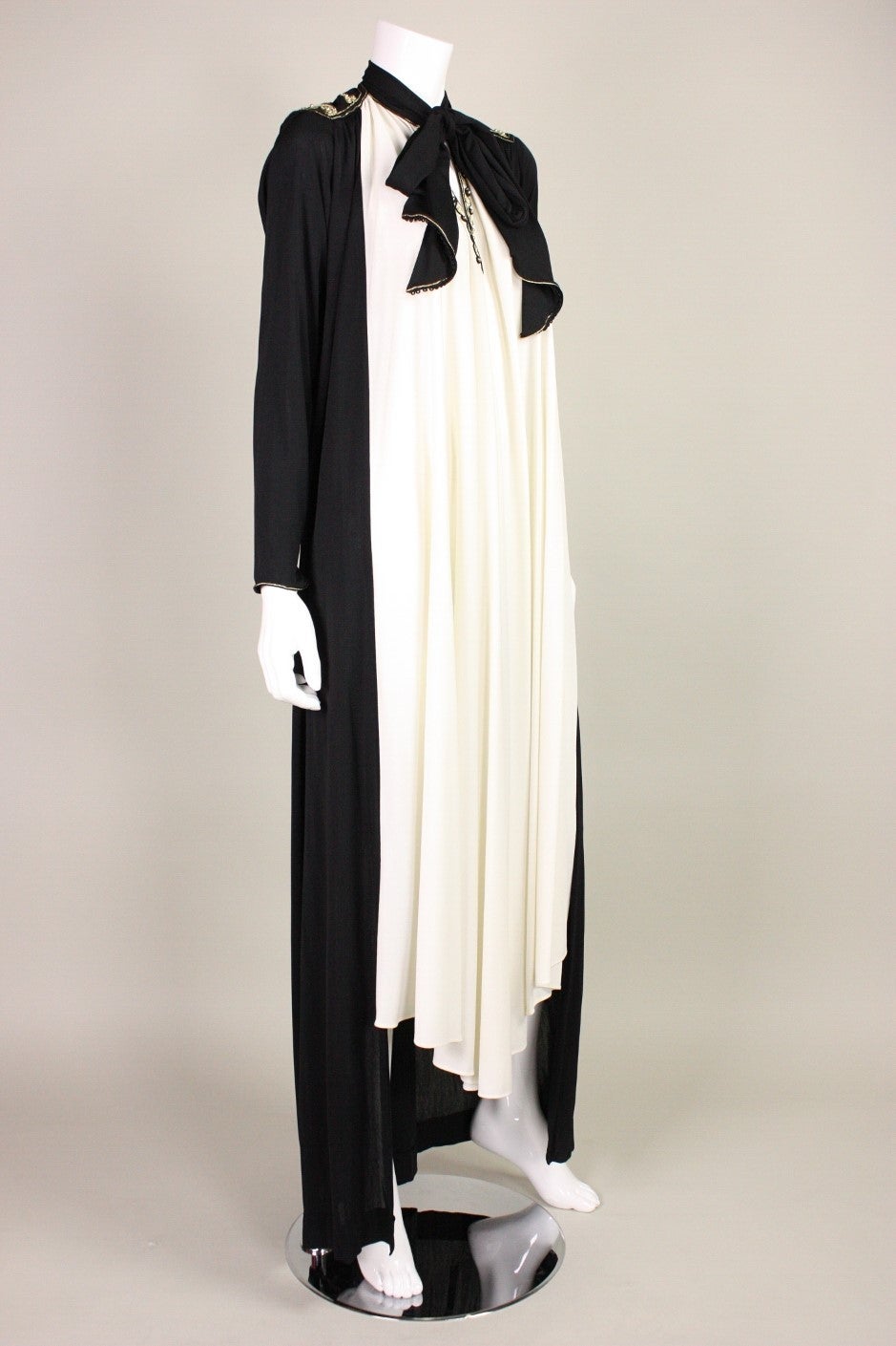 Vintage dress by Fakhita Sebti is made out of black and cream matte jersey.  Gold soutache detailing at center front neck and shoulders.  Center front tie at neck.  No closures.  Unlined.  Can be worn with or without gold belt (as shown).

No size