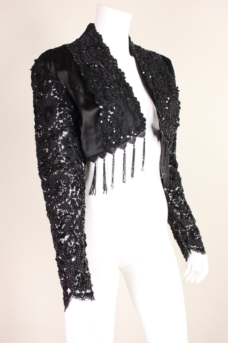 Vintage short jacket from Karen Boyd retailed at Maxfield in Los Angeles and dates to the 1990's.  It features beaded lace sleeves and trim.  Bodice is lined.  Sleeves are not.

Labeled size Small.