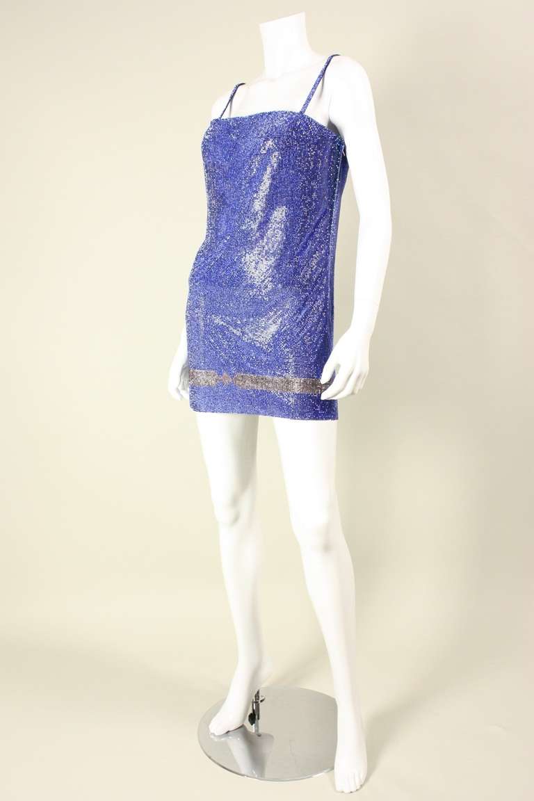 Glamorous dress from Gianni Versace dates to the 1990's.  It is made of metal mesh that is completely covered in sapphire blue crystals.  Interior satin bodice fits snugly against the body.  Side zipper.  Please note that triangular inserts have