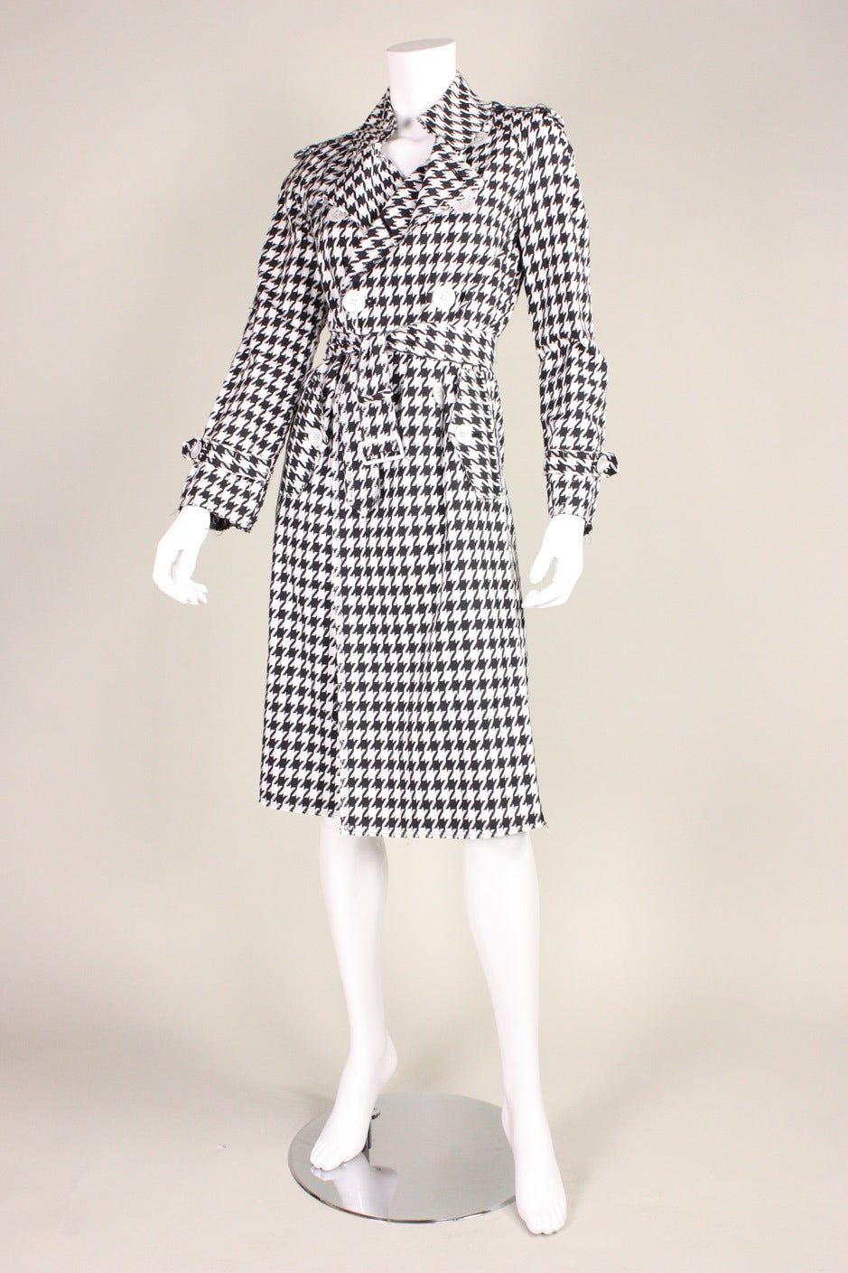Houndstooth trench from Junya Watanabe for Comme des Garcons dates to 2003.  It is made of loosely woven black and white lightweight cotton. Edges are unfinished. Double breasted with button closures.  Center back vent.  Detached belt. 