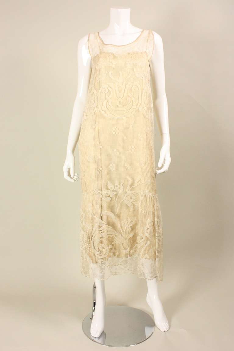 Vintage dress dates to the 1920's and is made of ecru filet lace with scrolling design.  It features a round neck, drop waist, and is sleeveless.  No closures.  Unlined, but comes with the slip shown in the photographs.

No size label, but